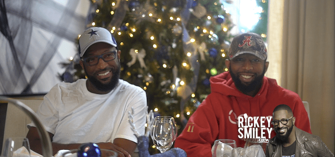 Two men smiling by a Christmas tree.
